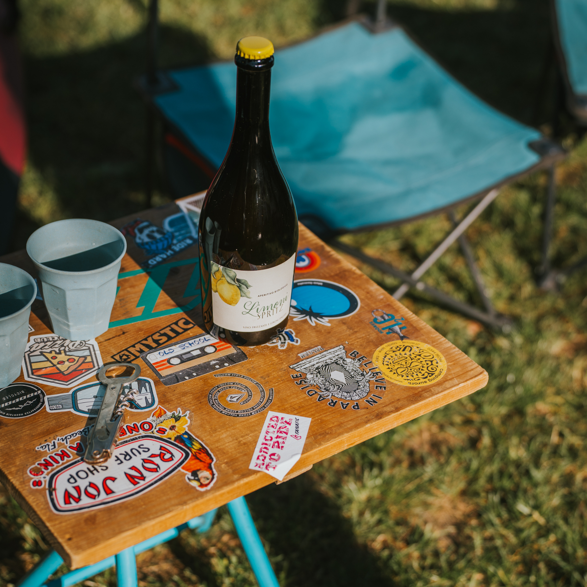 Limoni Spritz Flasche und 2 Becher auf einem bunten Campingtisch im Freien